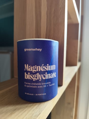 Le pot bleu de Magnésium Bisglycinate d'un client sur une étagère en bois.