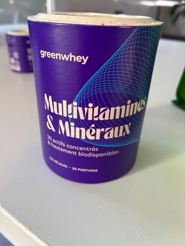 Client montrant le pot violet des Multivitamines & Minéraux.