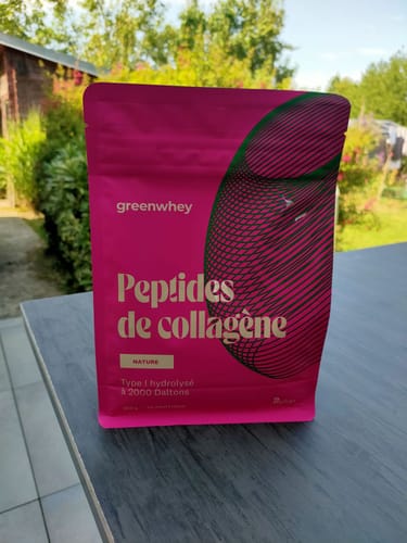 Client montrant le sachet rose de Peptides de Collagène posé sur une table en extérieur.
