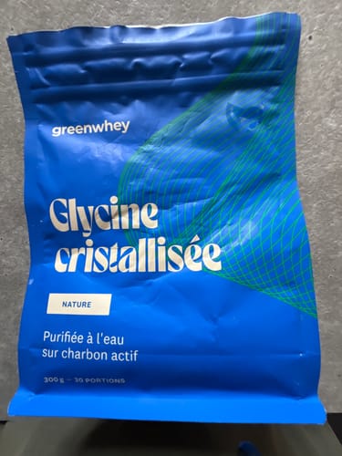 Client montrant le sachet bleu vif de Glycine cristallisée.