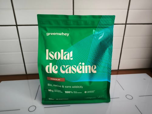 Le client montre son sachet d'Isolat de Caséine, saveur chocolat, posé sur une plaque de cuisson.