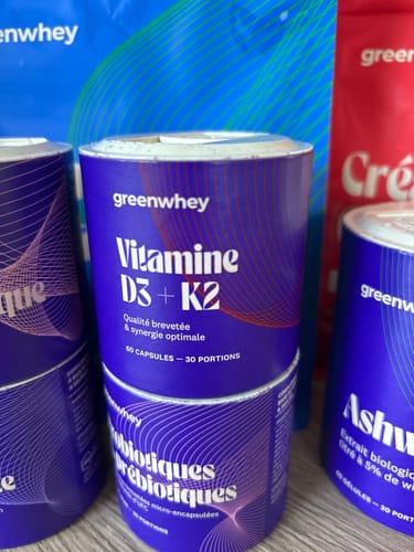Photo d'un client montrant le pot de Vitamine D3 + K2 au milieu de plusieurs autres suppléments.