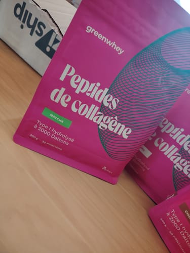 Photo d'un client montrant des sachets roses de Peptides de collagène, saveur matcha, posés sur une table.