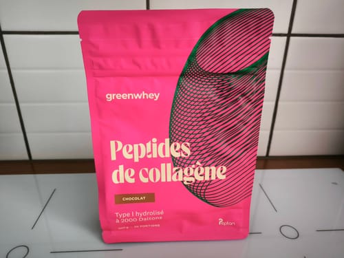 Le client montre le sachet rose vif des Peptides de Collagène saveur chocolat.