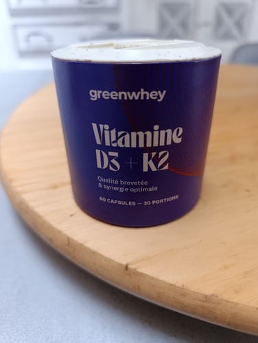 Avis d'un client : le pot bleu de Vitamine D3 + K2 posé sur une table en bois.