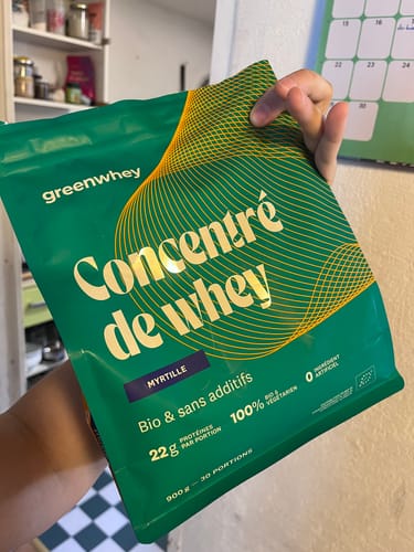 Client tenant le sachet vert de Protéine de Whey Bio, saveur myrtille.