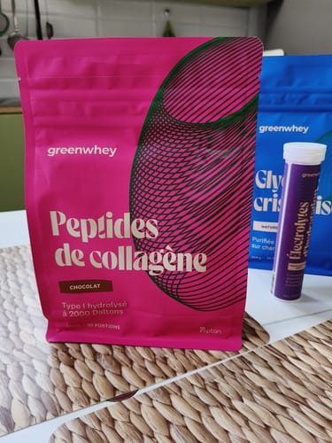 Client montrant le sachet rose des Peptides de Collagène au chocolat sur un set de table.