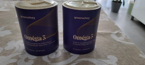 Les deux pots du supplément Oméga 3 d'un client, posés côte à côte sur une table.
