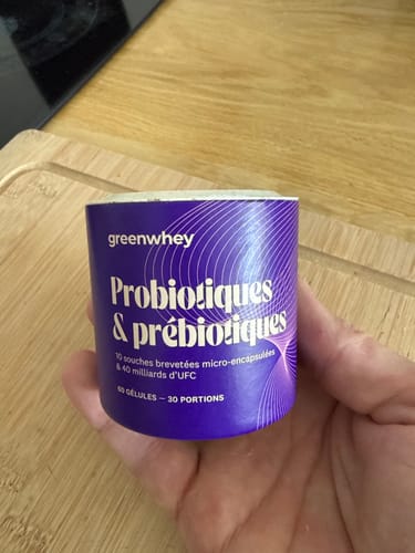 Un client tient dans sa main le pot violet de Probiotiques & Prébiotiques.