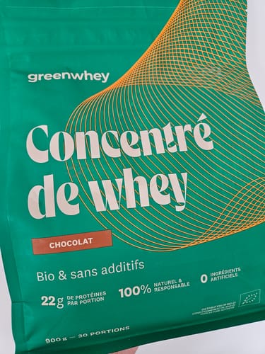 Photo d'un client montrant le sachet vert de Protéine de Whey Bioproduct, saveur chocolat.