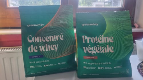 Un client montre son sachet de Protéine de Whey Bio à côté d'un autre sachet de protéine végétale.